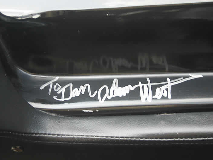 Adam West signs the "Rock Star" Batmobile.